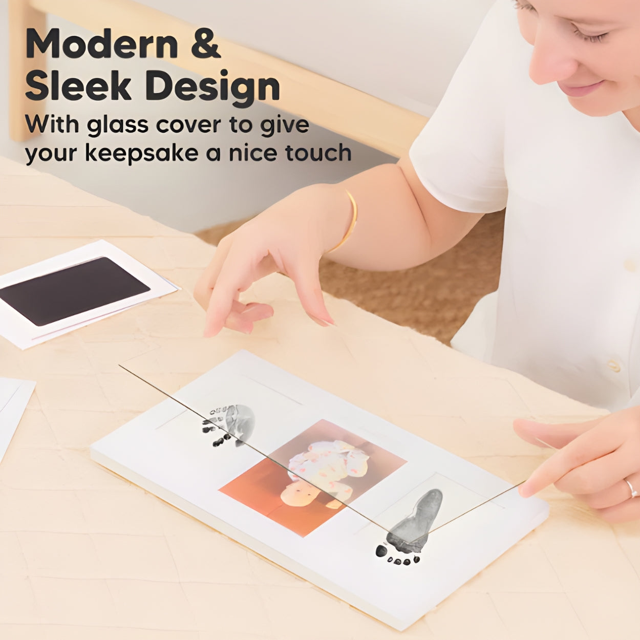 Person interacting with a product on a table, with text about modern design and glass cover. - Little Treasures